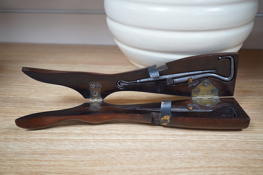 A Victorian rosewood 'ladys foot' etui holding a pair of steel bootpulls with additional tools to the handle, 26.5cm. Condition - good